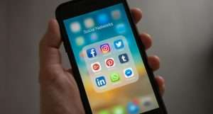 Persona Sosteniendo Iphone Mostrando Carpeta De Redes Sociales