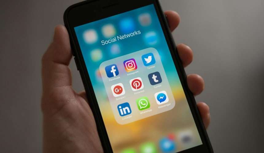 Persona Sosteniendo Iphone Mostrando Carpeta De Redes Sociales